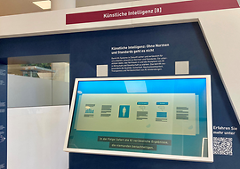 Abbildung des Exponats KI aus der Ausstellung im NormenWerk bei DIN. Wie Normung die KI unterstützt wird hier abgebildet.